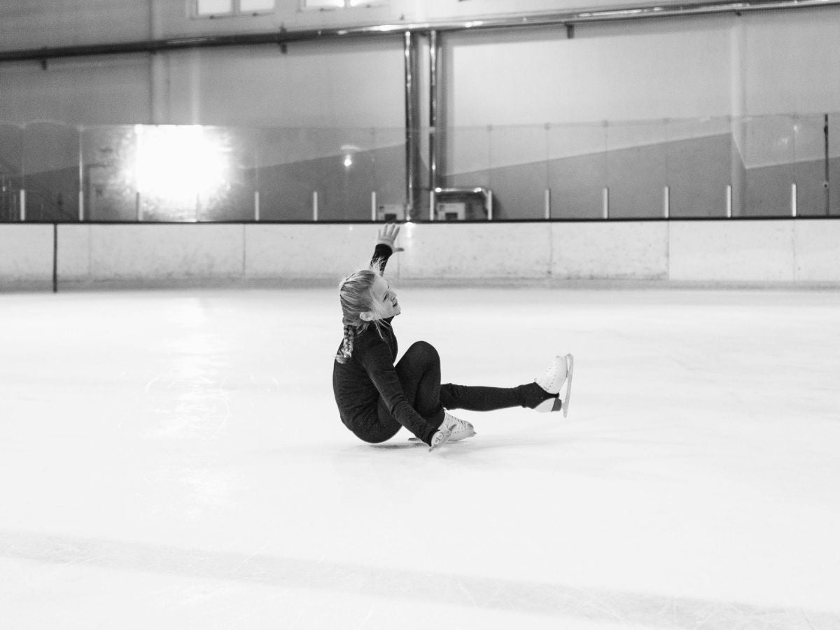 young figure skater falling during a training session