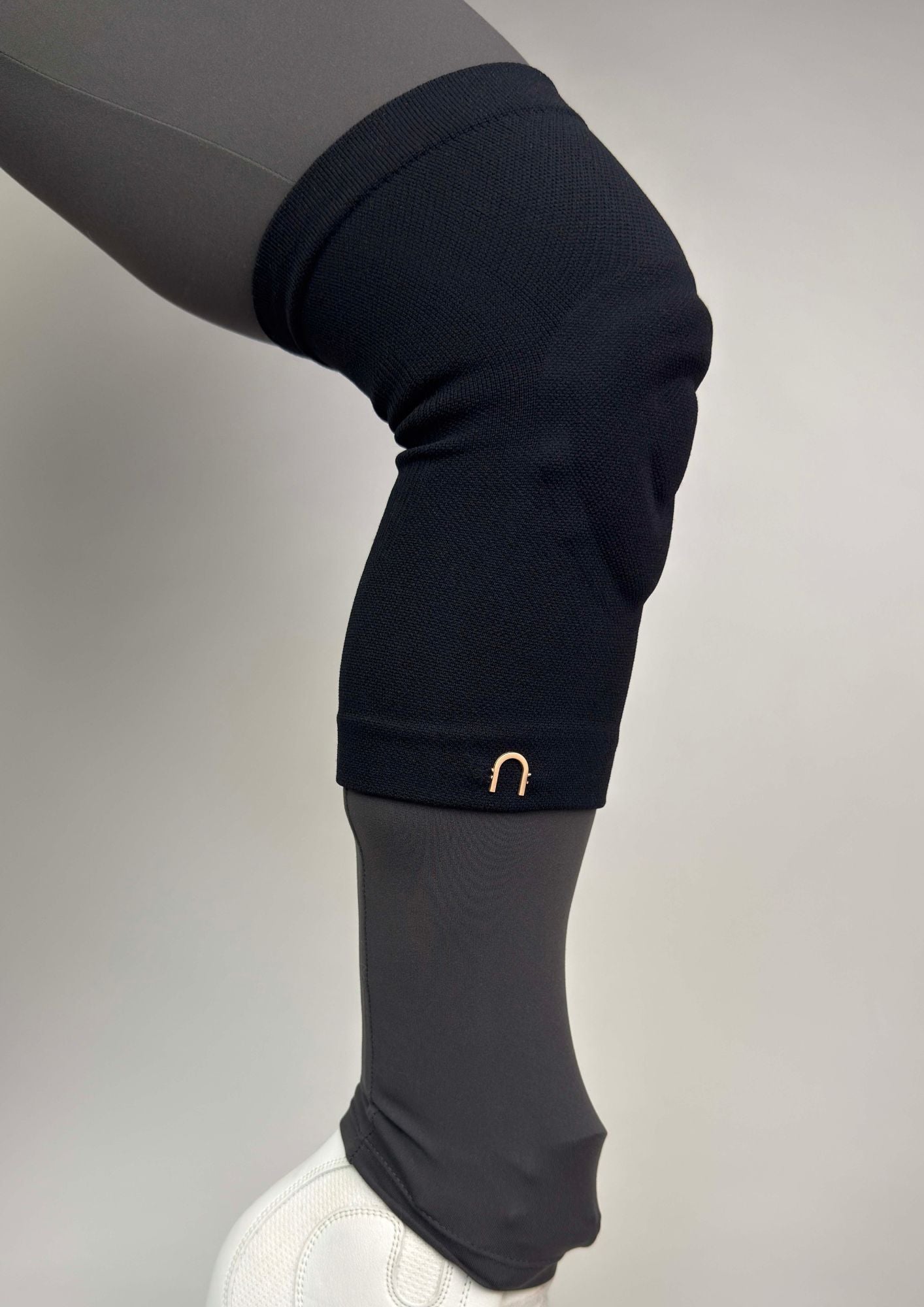 figure skater wearing black edge athletica knee guards with grey leggings