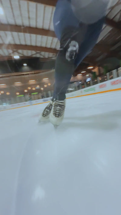 figure skater skating backwards with the edge athletica knee guards